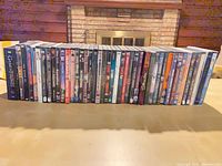 Full row of roughly 44 DVD cases standing on table