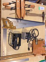 Entire assortment laid out including jigsaw, clamps, saw, hammer, rulers, yardstick, tool pouch