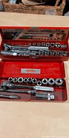Open Husky red metal case with ratchet, breaker bar, extensions and sockets visible