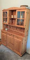 Front view of knotty pine hutch showing drawers, doors, glass panels, overall look
