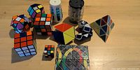 All eleven twisty and fidget puzzles arranged on tabletop showing variety of shapes and colours