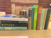 Stack of 12 hardcover science books, four horizontal and eight vertical