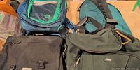 Four of the bags including MEC backpack, Roots shoulder bag, black messenger