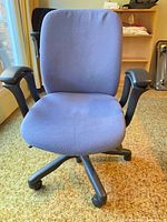 Front view of blue fabric office chair showing seat, back, armrests and casters