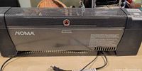 Front view of NOMA electric convector space heater showing grille, logo, power cord