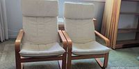 Front view of both bentwood chairs showing beige slipcovers and wood frames