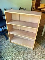 Front view of light maple laminate open bookcase with three shelves