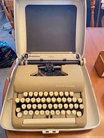 Typewriter inside open carrying case showing keys and carriage