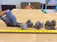 All five figurines lined up with ruler for scale