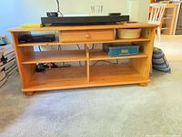 Front view of pine media stand showing drawer and shelves