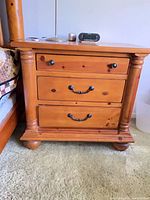 Front view showing three drawers, hardware, turned columns