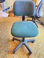 Front view of teal office chair showing seat, backrest and base