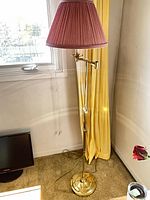 Full view of brass adjustable floor lamp with shade