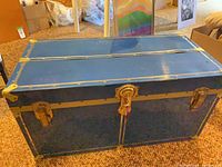 Front view of blue metal trunk showing lock and latches