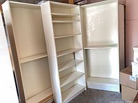 Front view showing three white Billy bookcases side-by-side, shelves and fixed bases visible