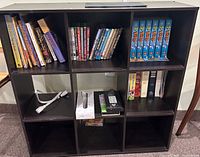 Front view of black 9-cube shelf showing overall design and contents for scale