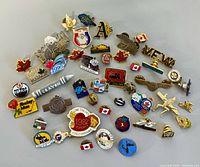 Full layout of 45 assorted pins on grey surface