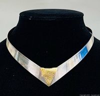 Full front view of V-shaped silver collar on display bust showing gold accent