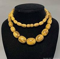 Necklace doubled on display bust showing bead size variation and color