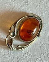 Front view showing amber cabochon and silver leaf frame