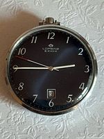 Front view showing dial, hands, numerals, date window