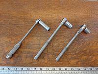 All three ratchet wrenches laid out with ruler for scale