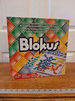 Front view of sealed Blokus board game box on table
