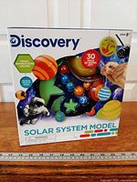 Front of sealed Discovery Solar System Model kit box showing branding, age 8+ and warning label