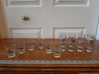 Full lineup of 11 shot glasses with ruler for scale