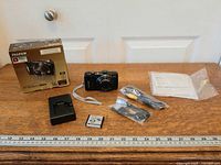 Full lot view: camera, box, charger, battery, cables, CD, manuals