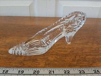 Right side view of clear cut crystal high-heel slipper showing faceted design and length against ruler