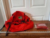 Backpack and sealed first aid kit side by side with ruler for scale