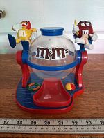 Front view of M&M's Make a Splash candy dispenser showing globe, base, and both character figures