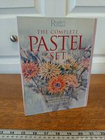 Front view of sealed Reader's Digest The Complete Pastel Set box showing title and floral cover art