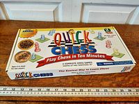 Front view of Quick Chess boxed game with ruler for scale