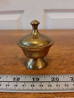 Side view showing full bowl with lid and ruler for scale