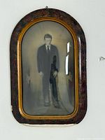 Full view of framed photograph showing convex glass and marbled frame