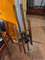 Front view of cast iron pulley mounted in wooden slat frame