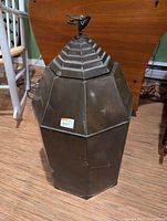 Overall view of octagonal metal bird feed holder with bird on top