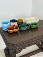 Group of eight assorted mid-century ceramic planters on table