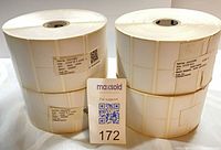 Four rolls of white labels standing vertically