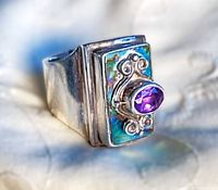 Front angled view showing amethyst, abalone inlay and silver scrollwork