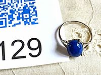 Top view of ring showing lapis lazuli stone and silver band beside lot number