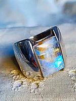 Front view showing wide silver band and rectangular moonstone
