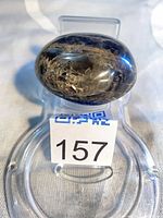 Oblique view of the polished black moonstone on stand showing overall size and shape