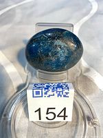 Front view of polished blue apatite stone displayed on stand