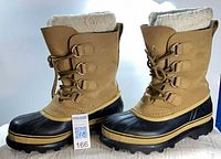 Side view of both boots showing leather upper, rubber lower, liners, lug soles