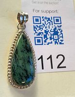 Front view of teardrop ruby in zoisite pendant with beaded bezel and bail