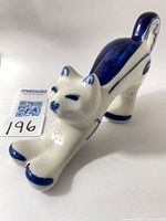 Front angled view of blue and white Gzhel stretching cat figurine