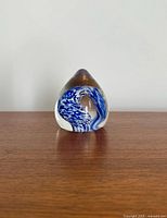 Front view showing teardrop shape, blue and white swirl, amber tip